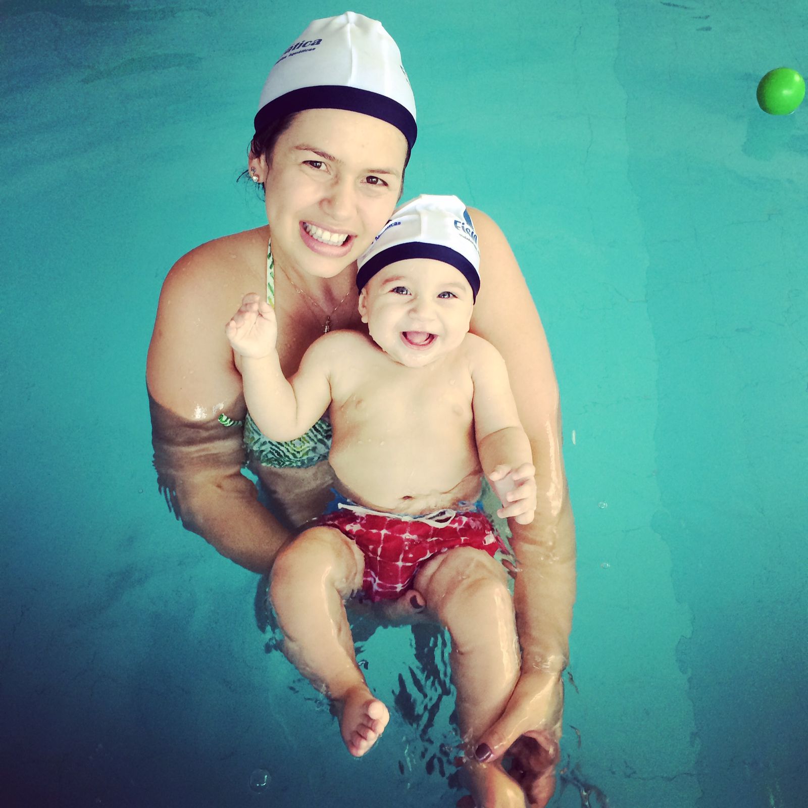 Bebê em aula de natação com acompanhamento na piscina aquecida
